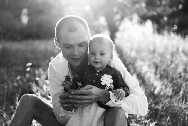Tender black and white image showcasing a father and daughter sharing a moment in nature.